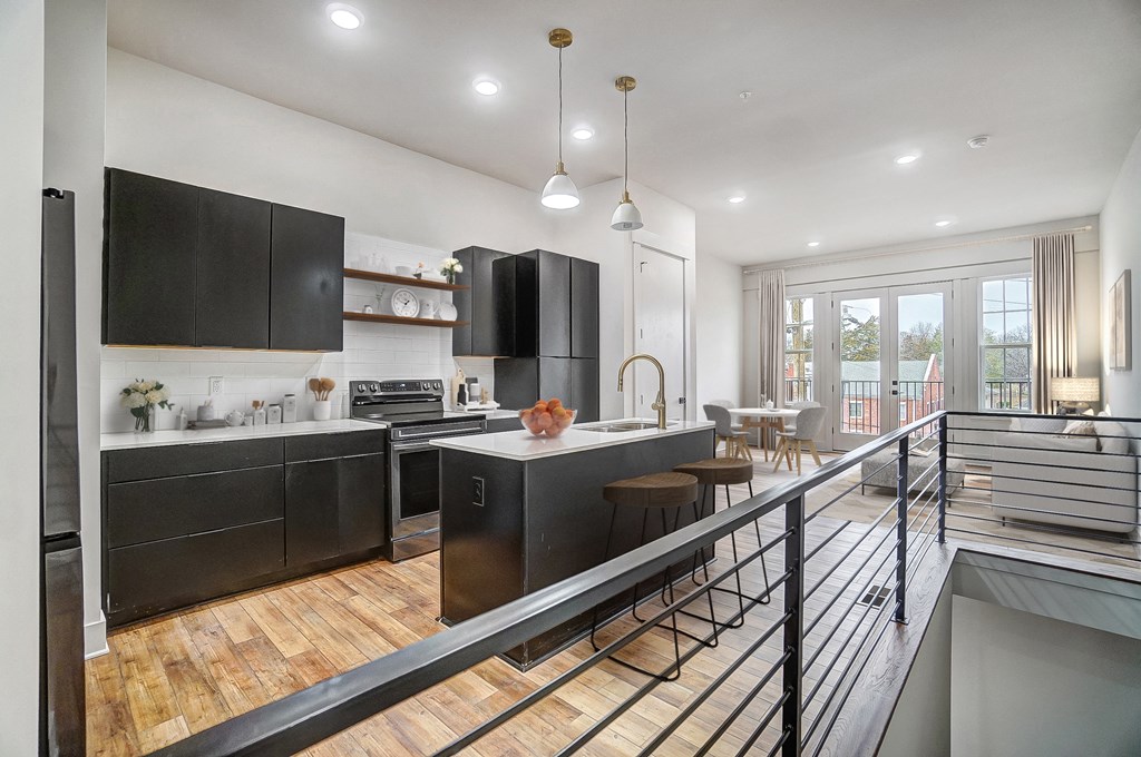 a large kitchen with black cabinets and a balcony