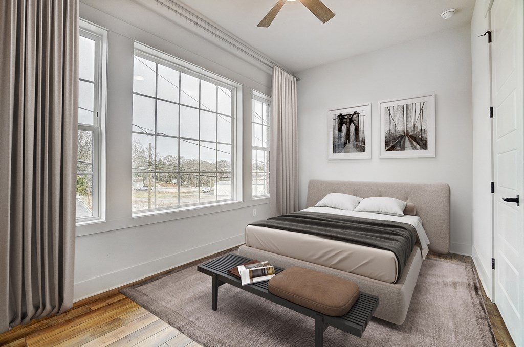 a bedroom with a bed and a large window