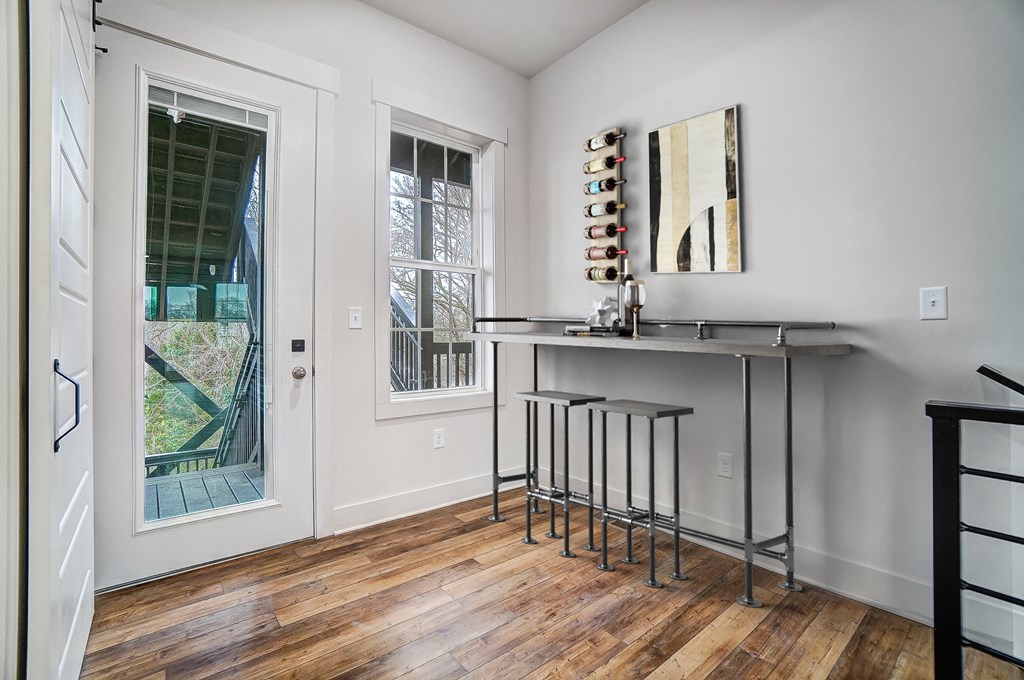 an empty room with a bar and a door to a backyard