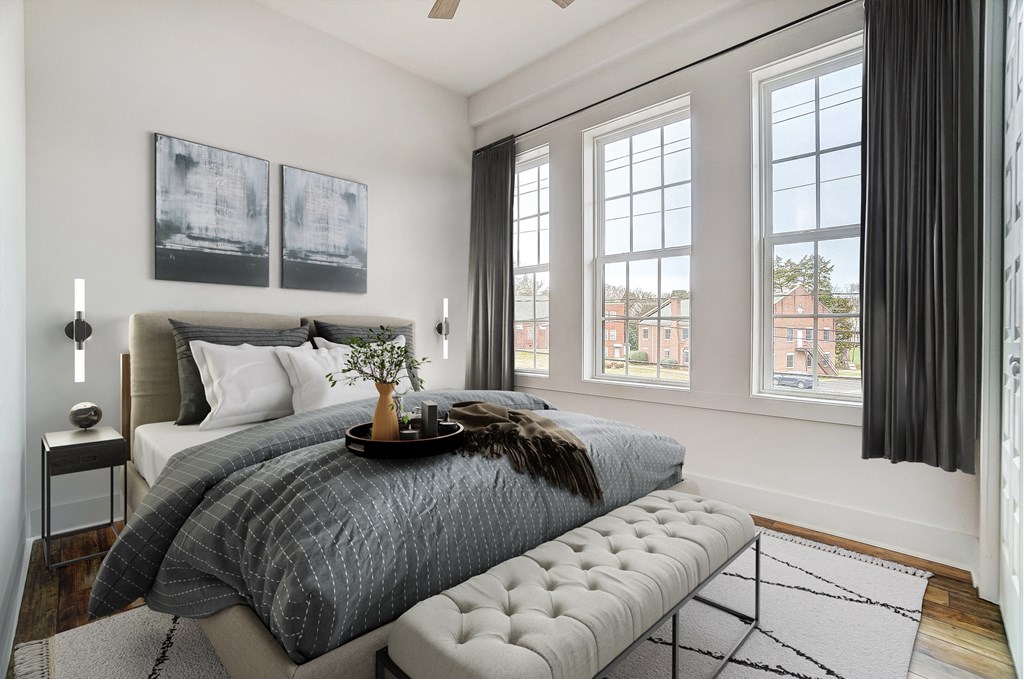 a bedroom with a bed and three windows