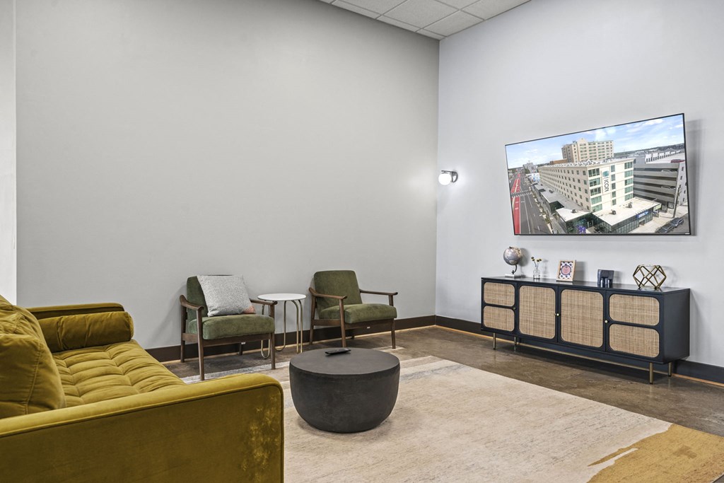 a lounge area with couches chairs and a coffee table with a flat screen tv on the  at The Icon, Richmond, VA 23230