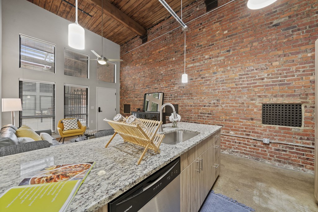 a kitchen with a counter top next to a living room