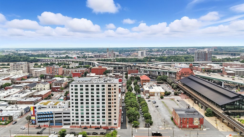 A cityscape with a large building in the center and a train station to the right.