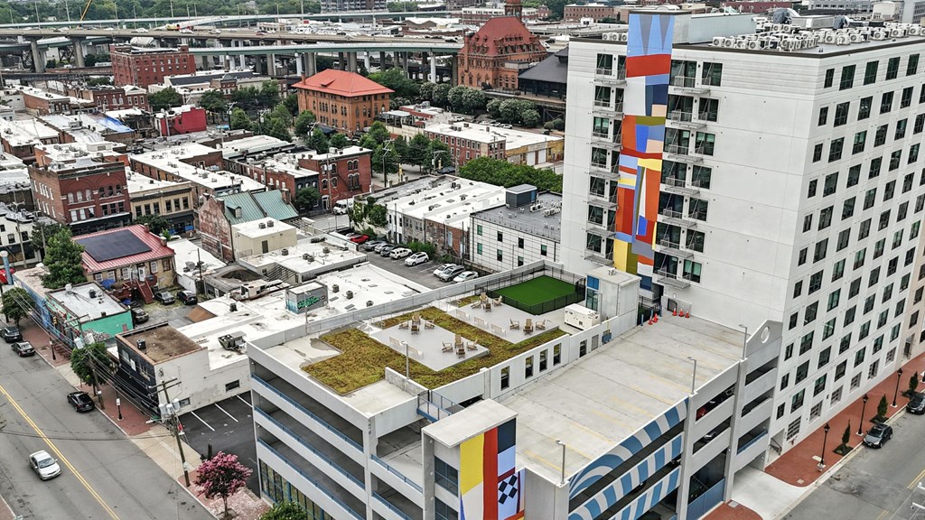 A cityscape with a large white building with a green roof in the center.