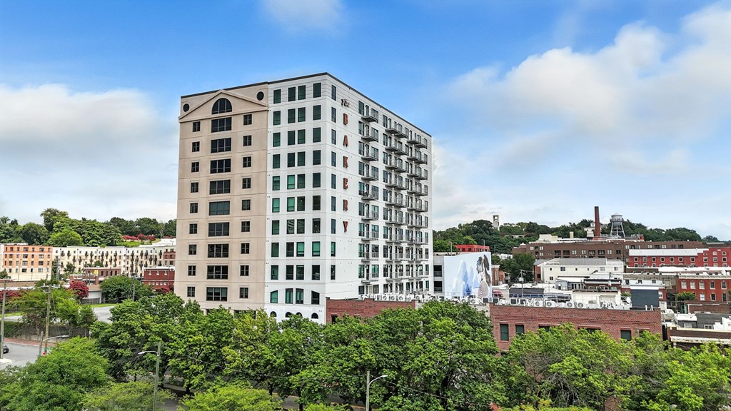 A tall white building with a green lawn in front of it.