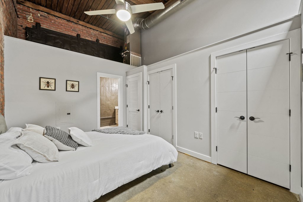 a bedroom with a bed and a ceiling fan