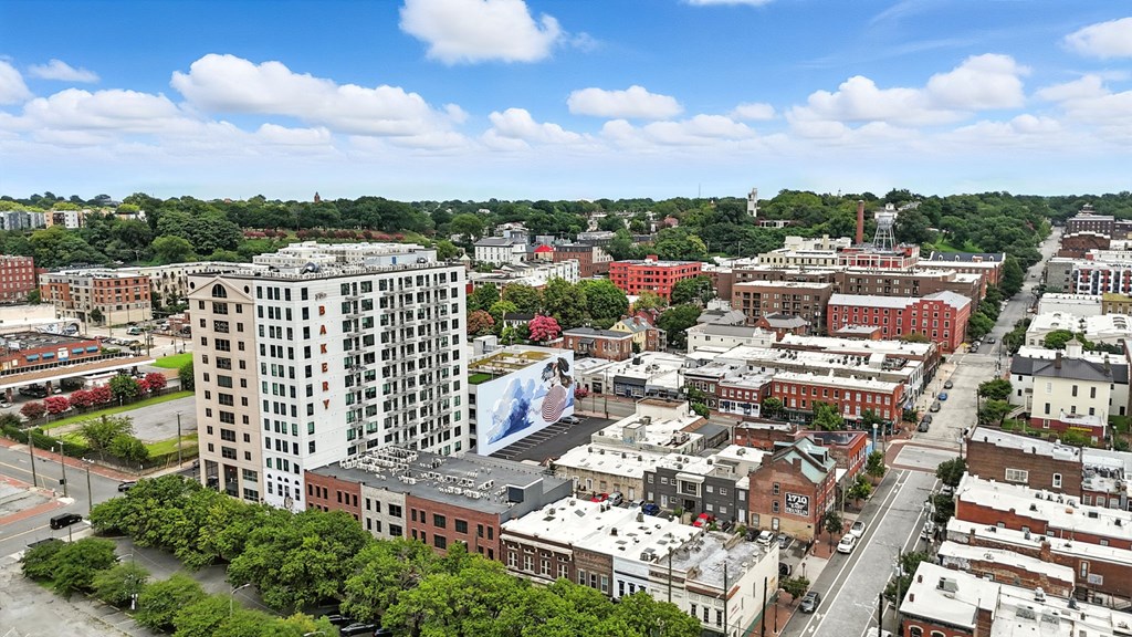 A cityscape with a large building in the foreground and a clear blue sky above.