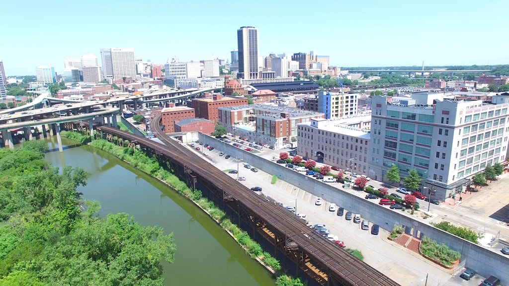 an aerial view of a city with a river and train tracks