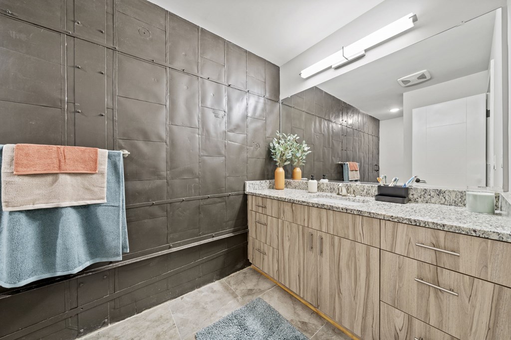 a bathroom with a large mirror and a long counter with a sink and a mirror