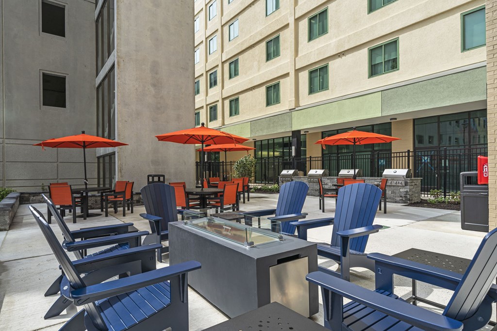 a patio with chairs and umbrellas in front of a building  at The Icon, Richmond, VA, 23230
