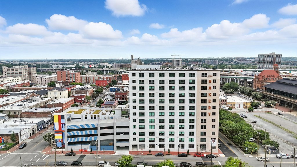 A tall building with many windows is in the middle of a city.