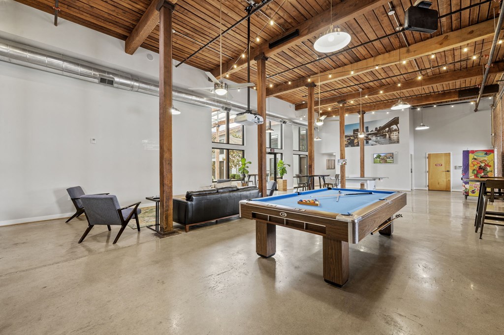 a pool table in a large room with a couch and chairs