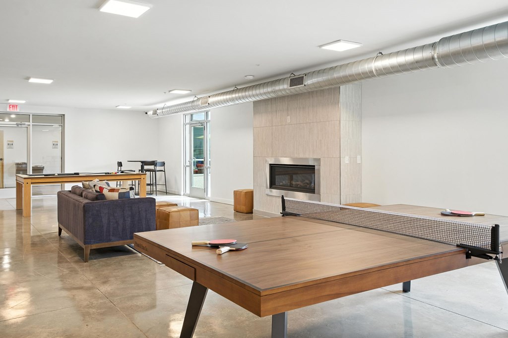 A modern living room with a fireplace and a long wooden table.