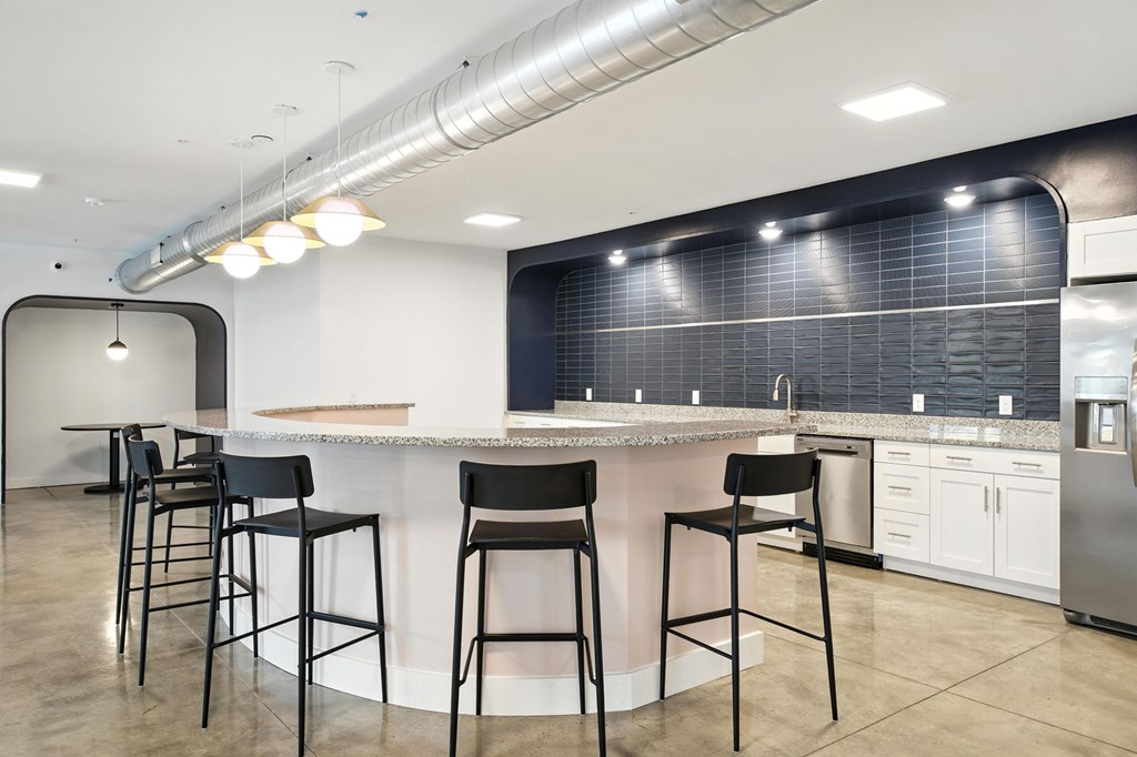 A kitchen with a bar area and stools.