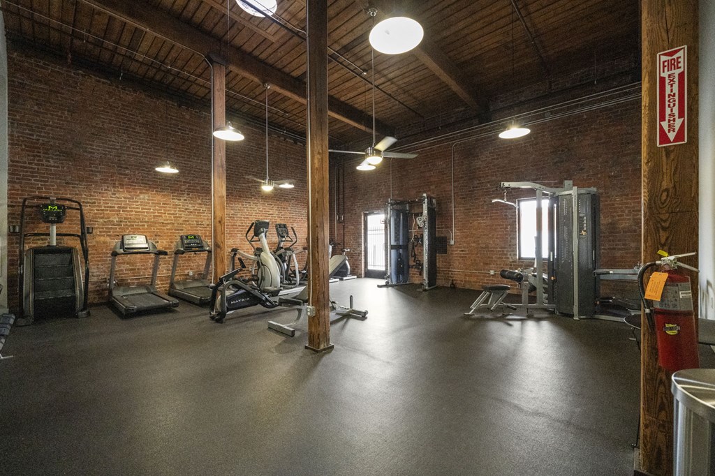a gym with brick walls and a wooden ceiling