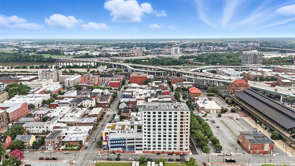 A cityscape with a large building in the center and a highway running through it.