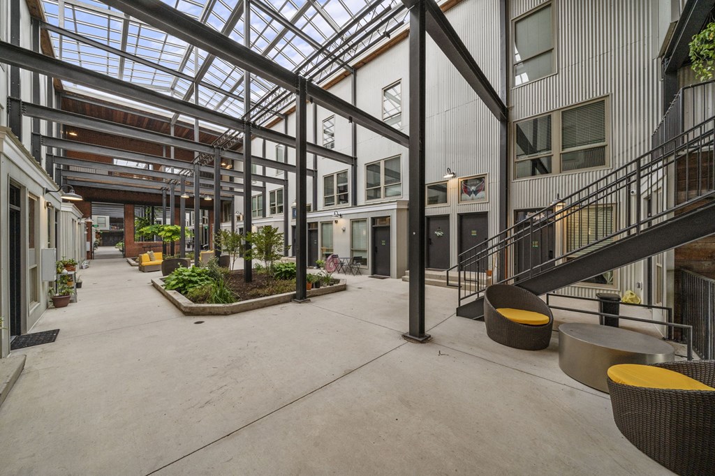 a large open space with a glass ceiling and a staircase with a yellow bench