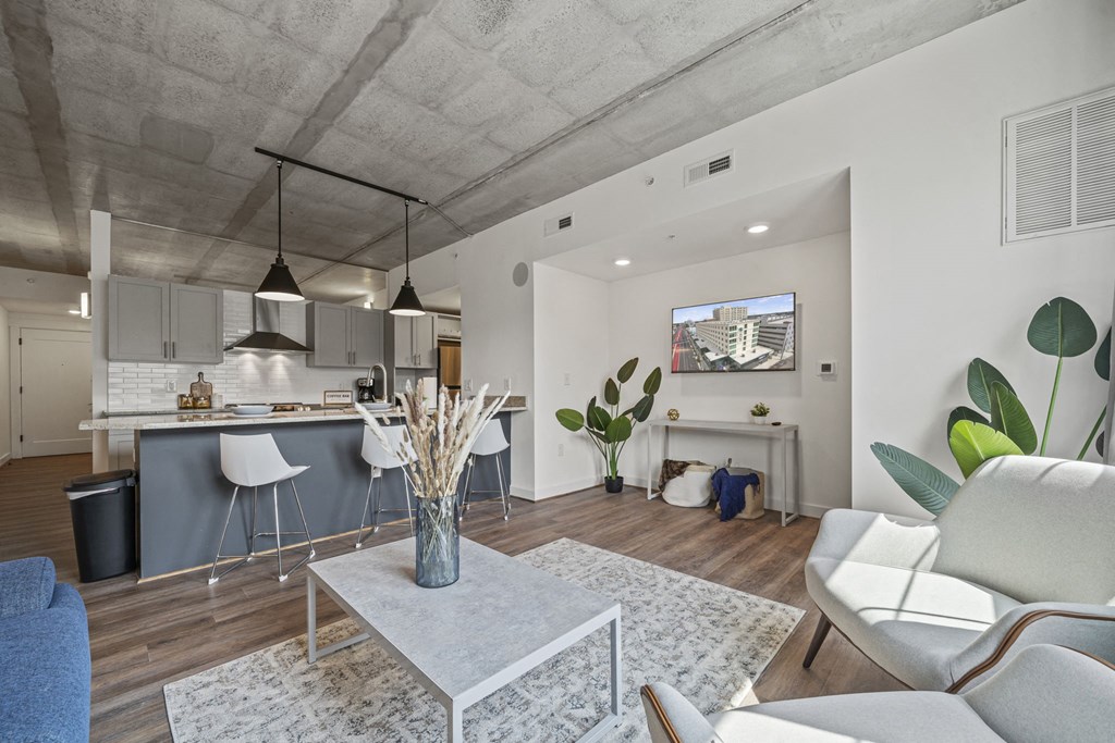 a living room with white walls and hardwood floors at The Icon, Richmond, VA 23230