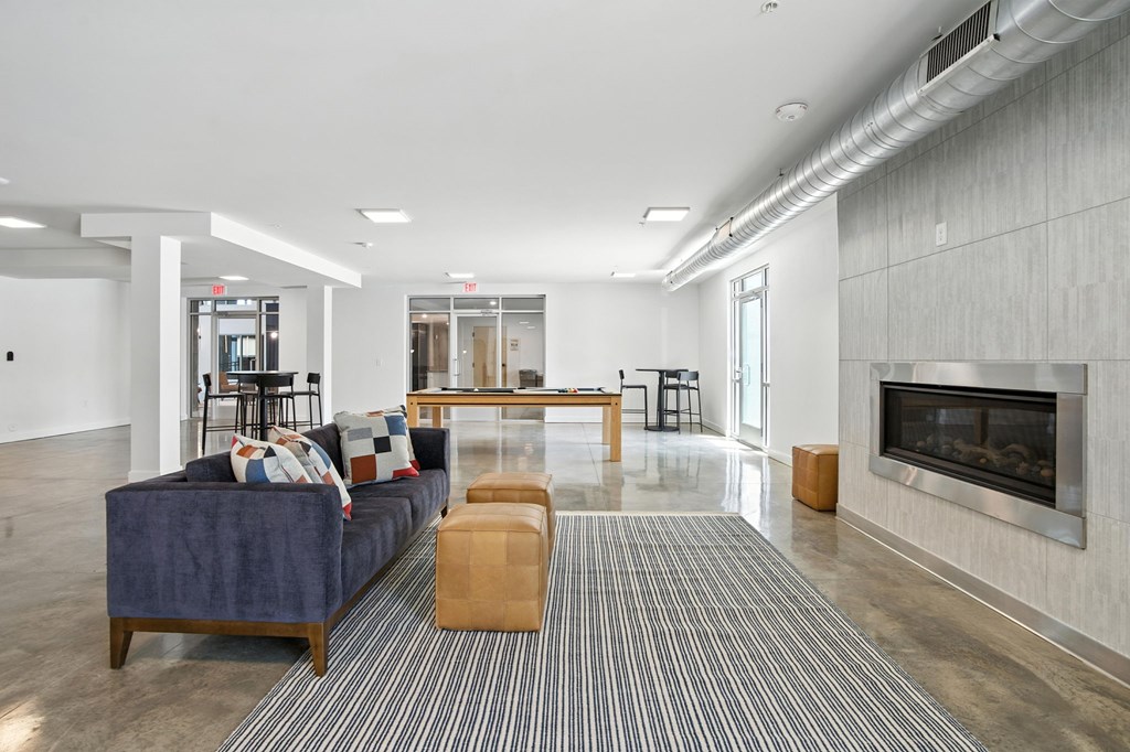 A modern living room with a fireplace and a blue couch.