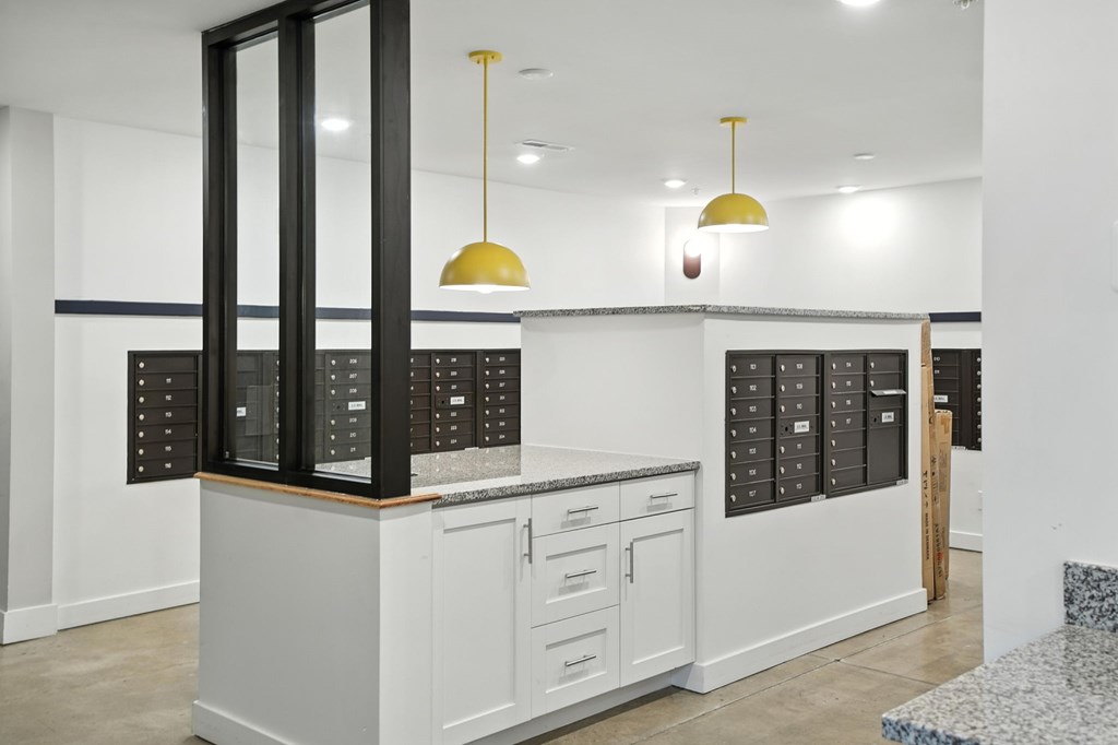 A kitchen with white cabinets and a black fridge.