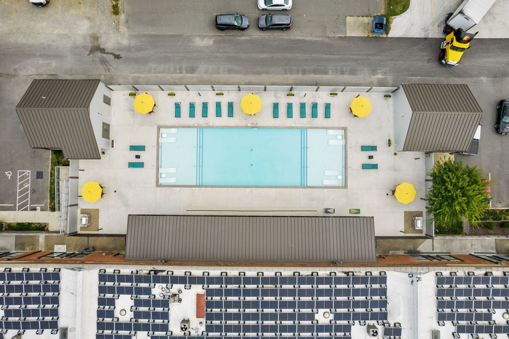 an overhead view of a building with a pool and cars parked around it