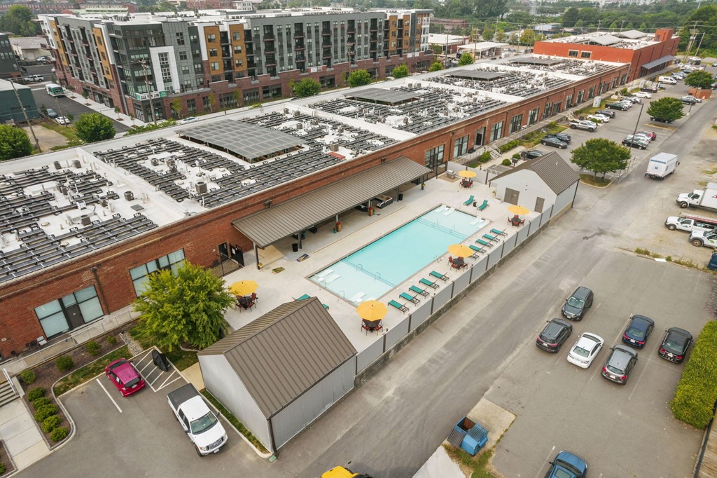 a large brick building with a pool and solar panels on top of it