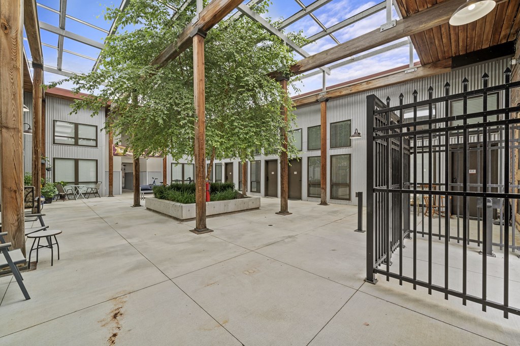 a courtyard with a metal gate and trees