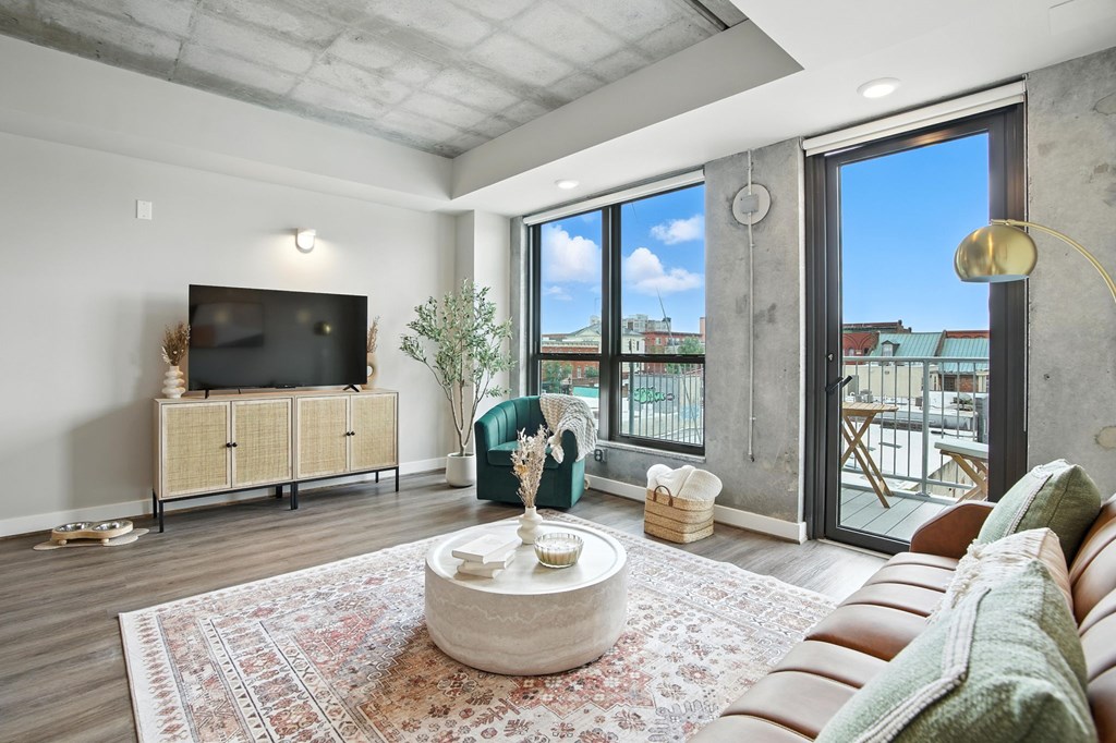 A living room with a flat screen TV and a view of the city.