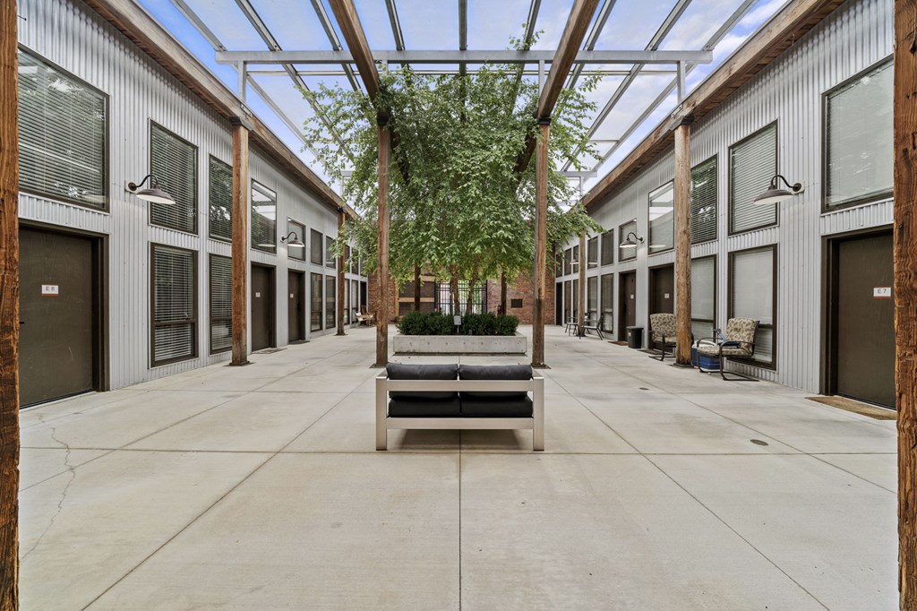 a courtyard with a bench and trees in the middle of it