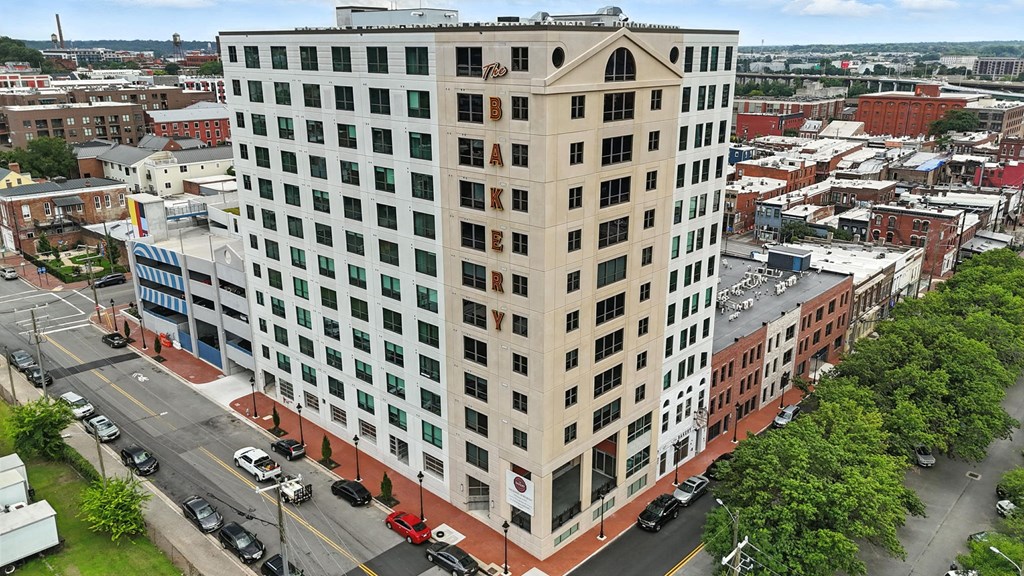 A tall building with the word "ARK" on the side is surrounded by other buildings and trees.