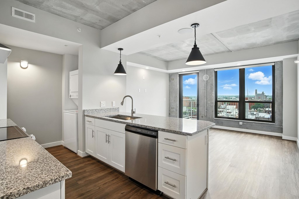 A modern kitchen with a granite countertop and stainless steel appliances.