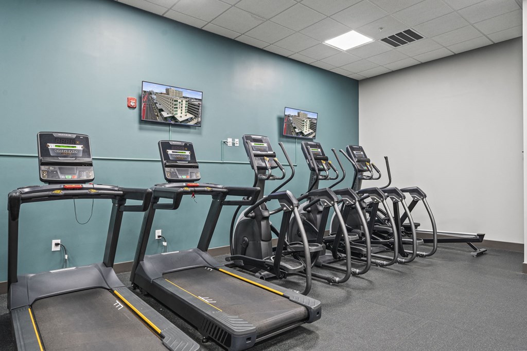 a room filled with cardio machines and a flat screen tv at The Icon, Richmond, VA 23230