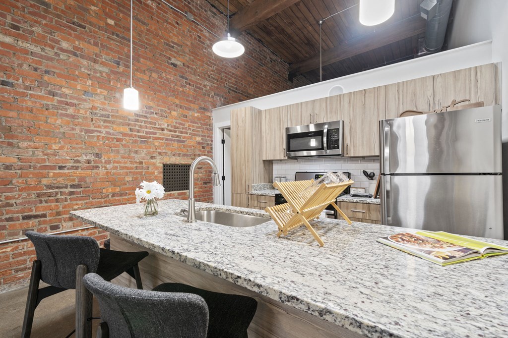 a kitchen with a large island and a stainless steel refrigerator