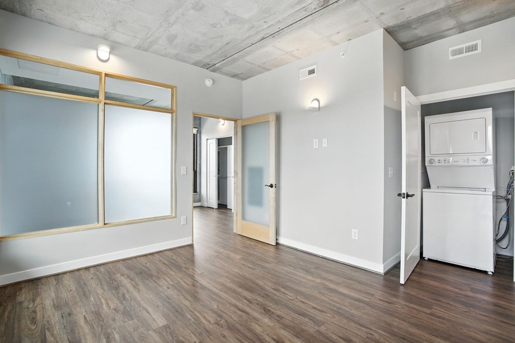 A kitchen area with a white fridge and wooden floors.