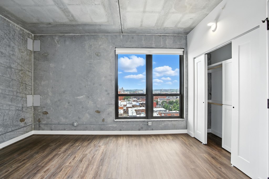 A room with a large window overlooking a cityscape.