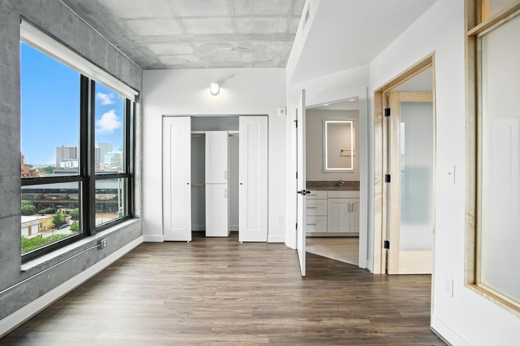 A spacious, empty room with white walls and wooden floors.