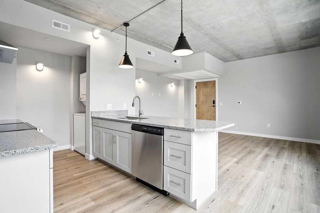 A modern kitchen with a white countertop and stainless steel appliances.