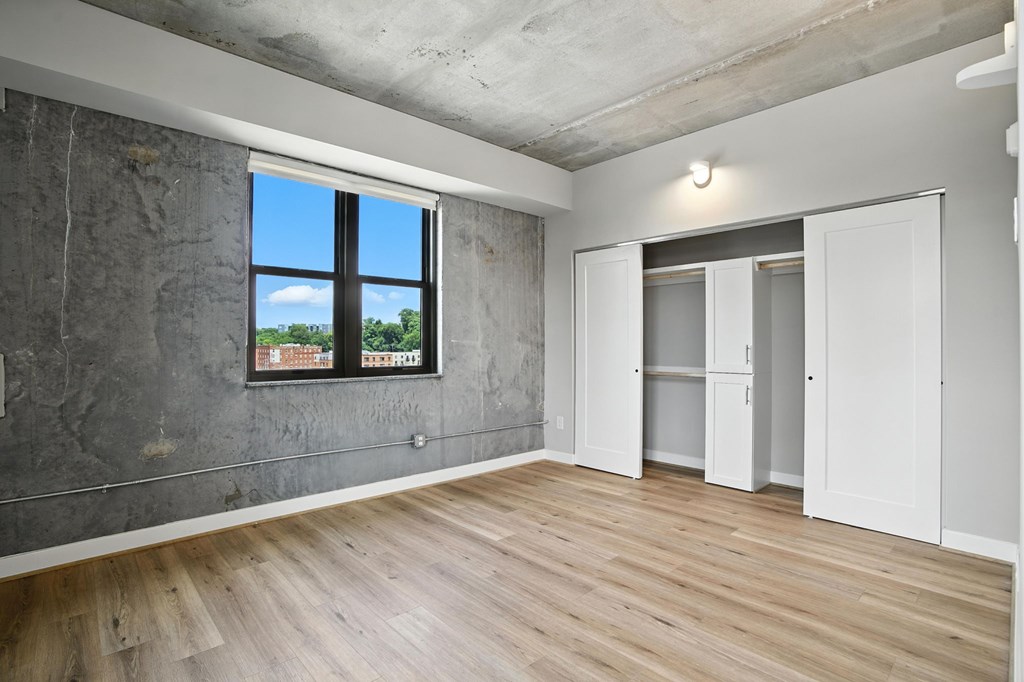 A room with a large window and wooden flooring.