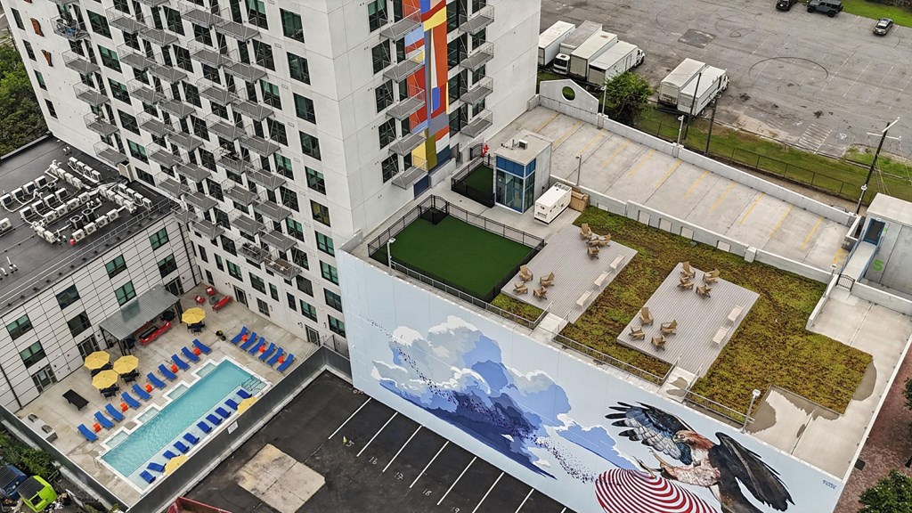 A mural on the side of a building depicts a whale and a woman.