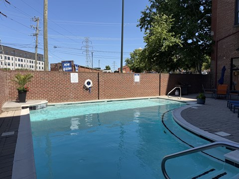 A pool with a brick wall and a sign that says "NOW" on it.