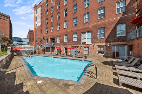a swimming pool at a hotel with a brick building