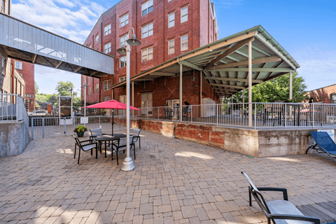 a patio with tables and chairs outside of a building