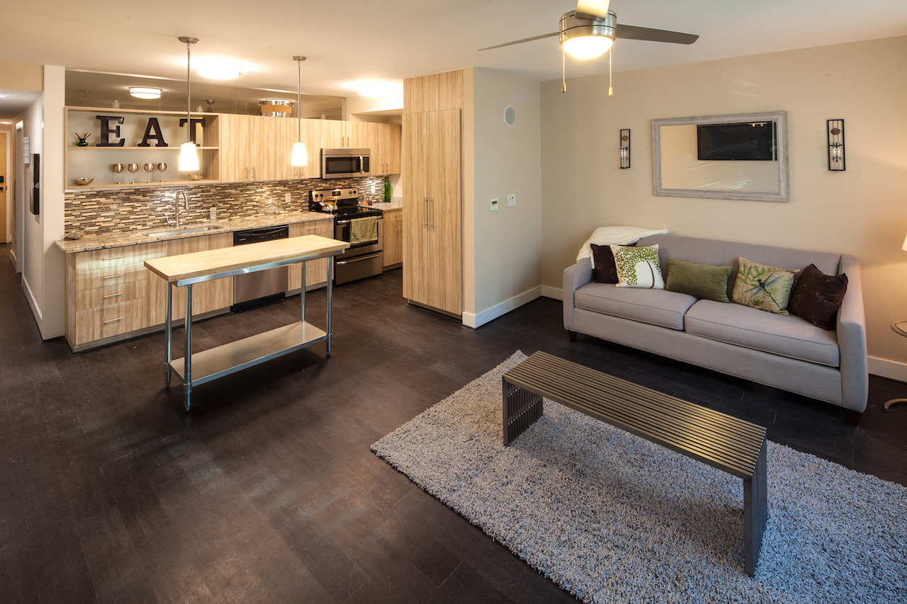 a living room and kitchen with a couch and a table