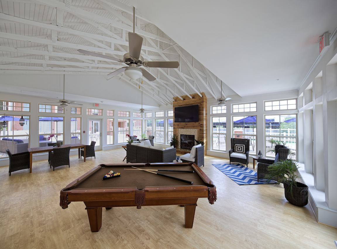 a living room with a pool table and a ceiling fan