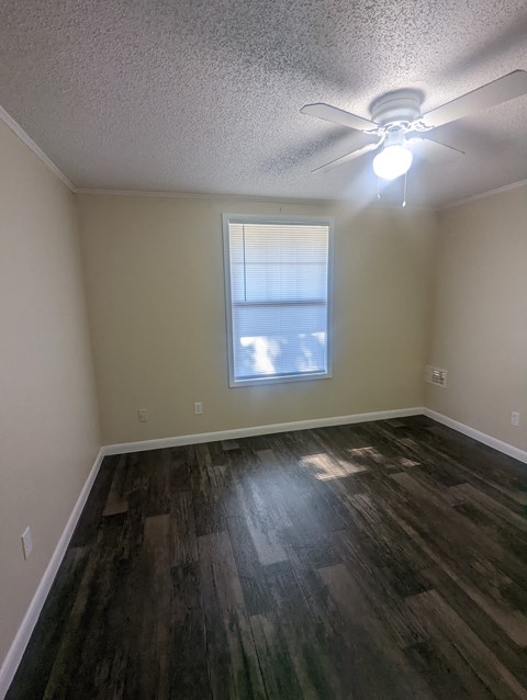 a bedroom with hardwood flooring and a ceiling fan