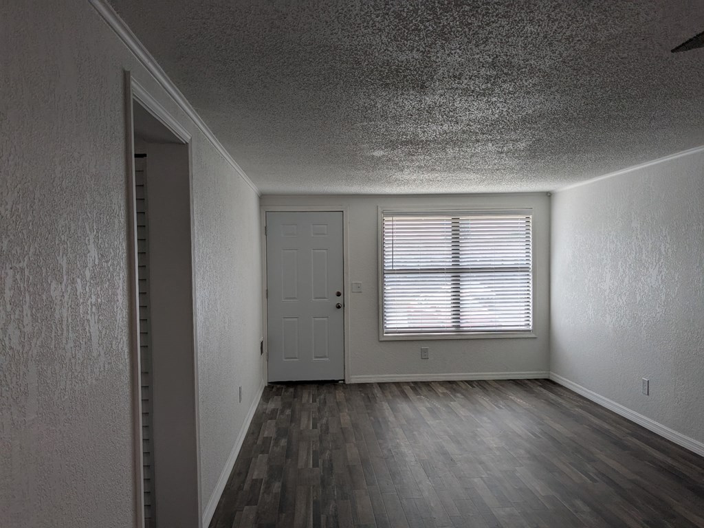 A room with a door and a window with blinds.