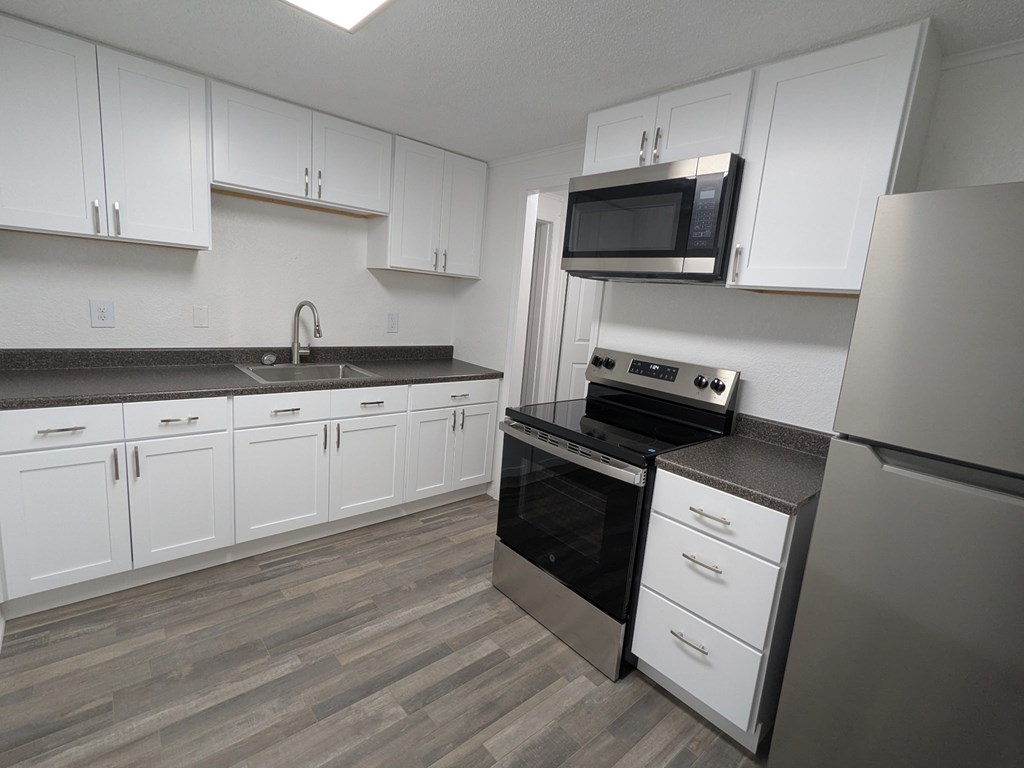 A kitchen with white cabinets and a black oven.