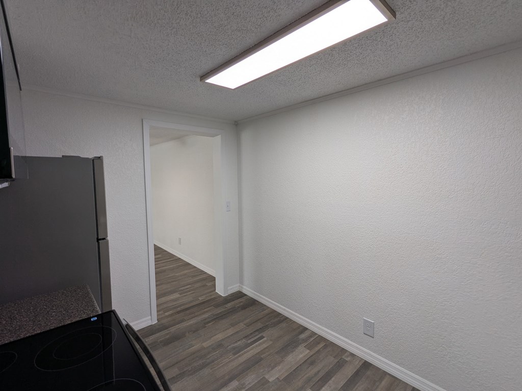 A kitchen with a black stove top oven and a white wall.