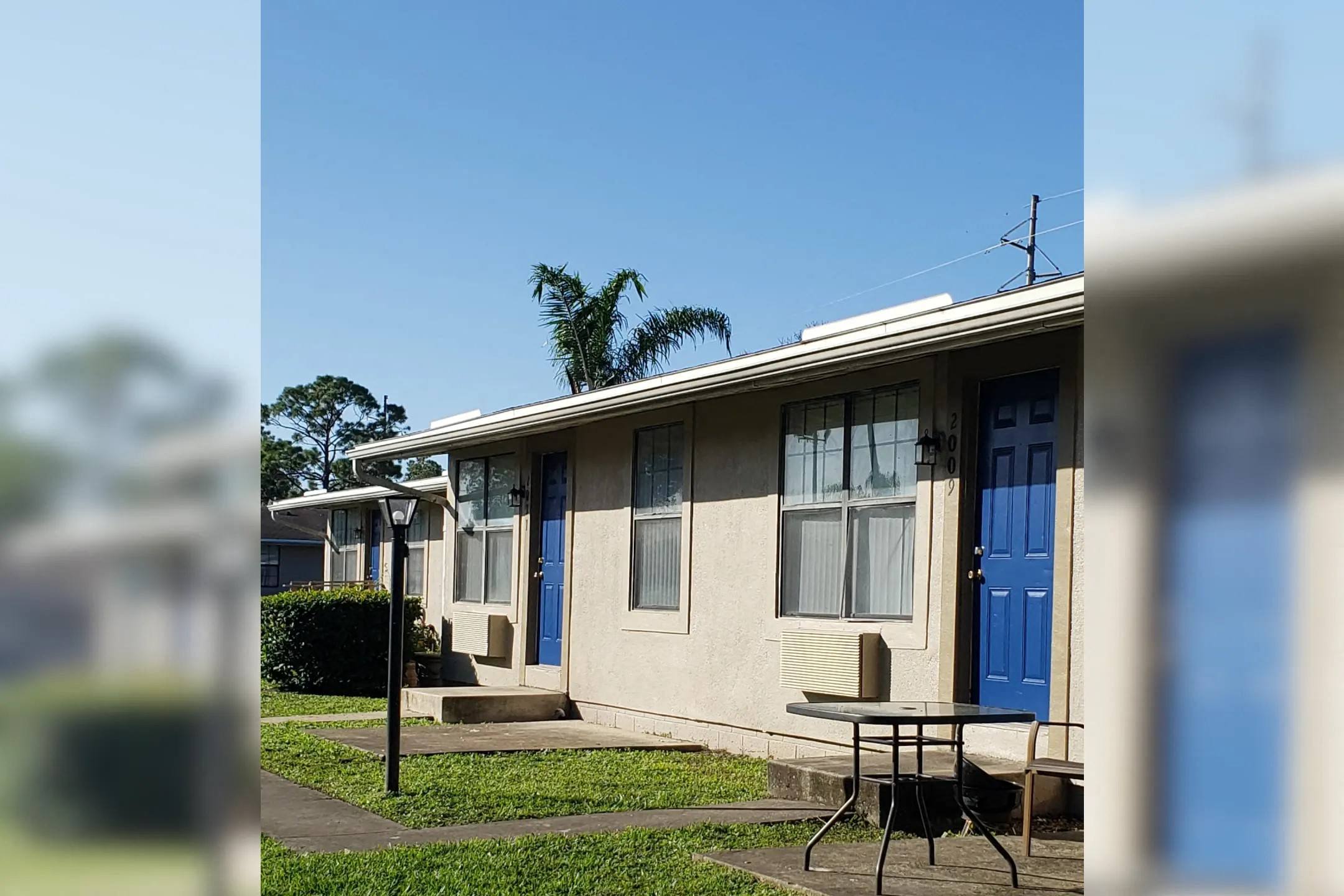 a house with a blue door and a table in front of it