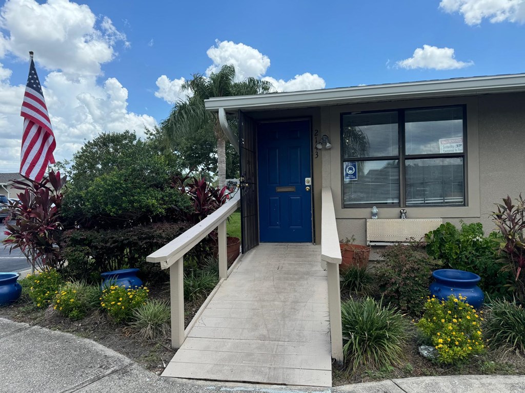 a home with a blue door and a porch with an flag